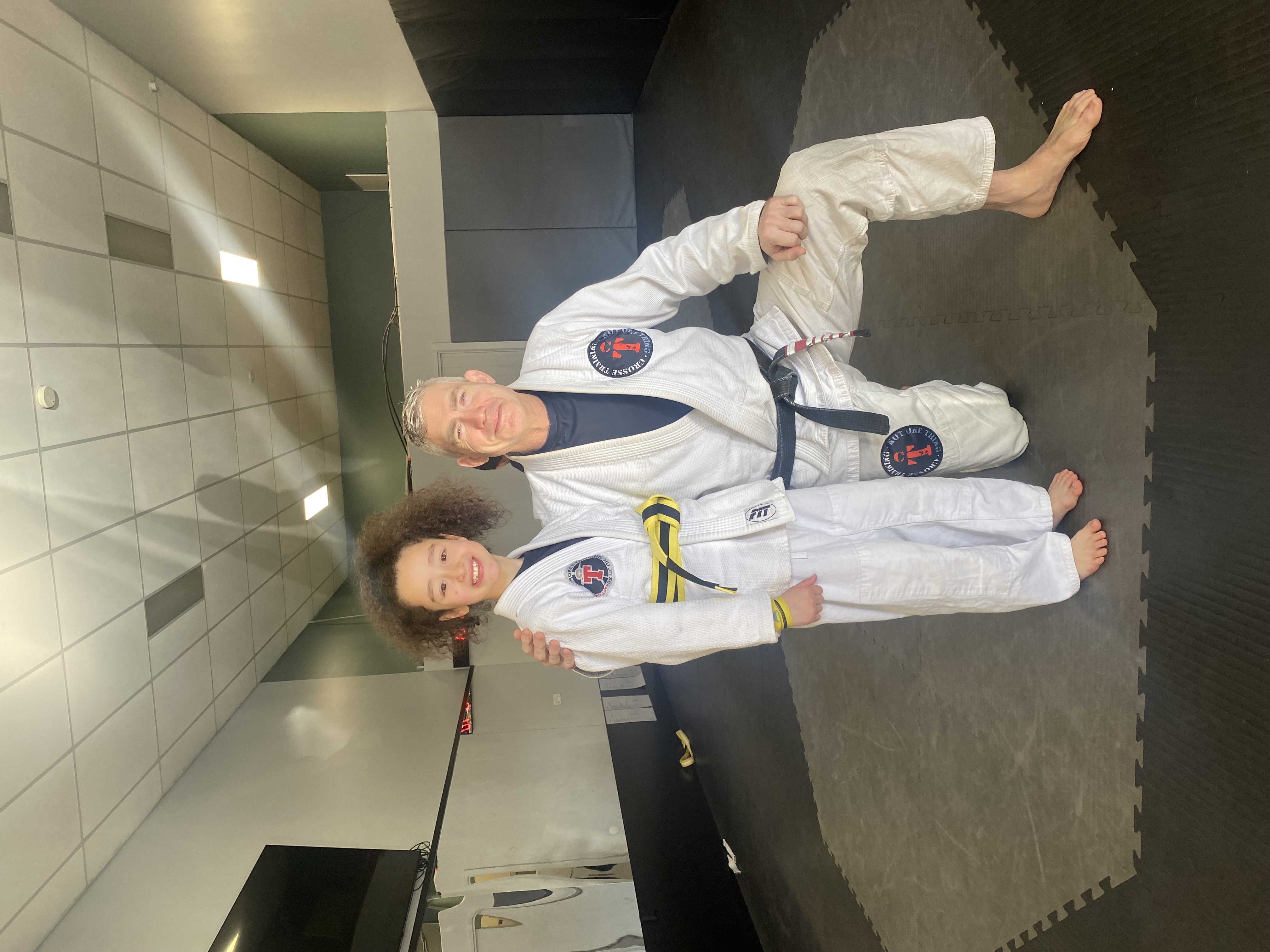 Crosse Training coach and young student in white jiu-jitsu uniforms